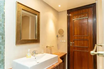 a bathroom with a sink and a mirror and a door at Marrakech Private Pool Villa in Marrakech
