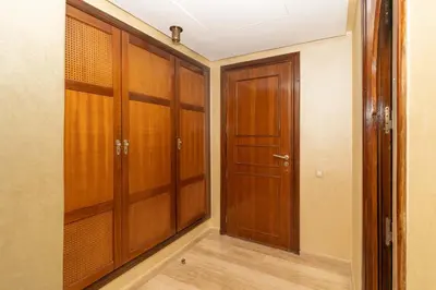 a walk in closet with wooden cabinets and a door at Marrakech Private Pool Villa in Marrakech