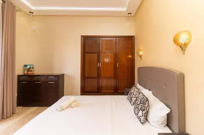 a bedroom with a bed and a wooden cabinet at Marrakech Private Pool Villa in Marrakech