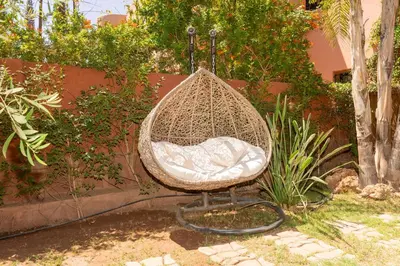 a swing chair sitting in a garden at Marrakech Private Pool Villa in Marrakech