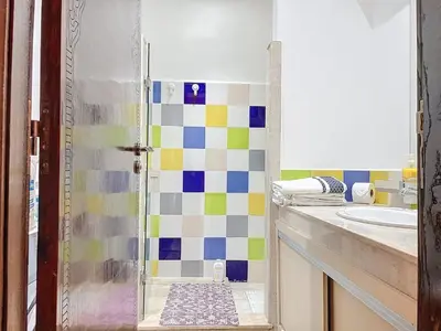 a bathroom with a sink and a shower with colorful tiles at Cosy and spacious apartment in Gueliz in Marrakech