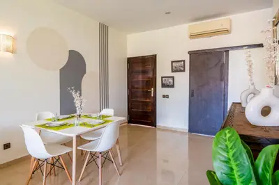 a dining room with a white table and white chairs at Appartement d'Exception-Piscine in Marrakech