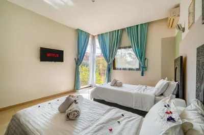 a hotel room with two beds and a window at Appartement d'Exception-Piscine in Marrakech