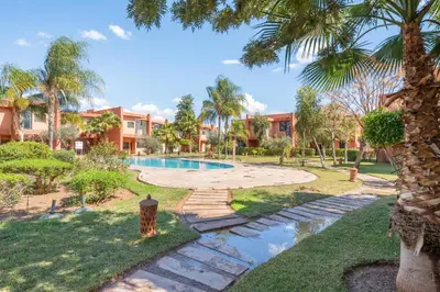 a villa with a swimming pool and palm trees at Appartement d'Exception-Piscine in Marrakech