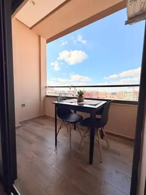 a dining room with a table and a large window at Appartement au cœur de Marrakech in Marrakech