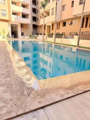 a swimming pool in front of a building at Appartement au cœur de Marrakech in Marrakech