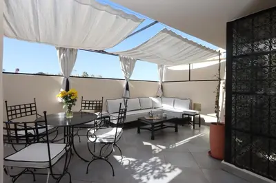 a patio with a table and chairs and a tent at Souffle d 'Orient, easy access to medina & basin in Marrakech