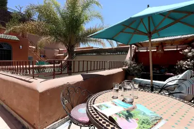 a table with chairs and an umbrella on a patio at Riad Al Kamar, private, 2 min from Jema El Fna Square in Marrakech