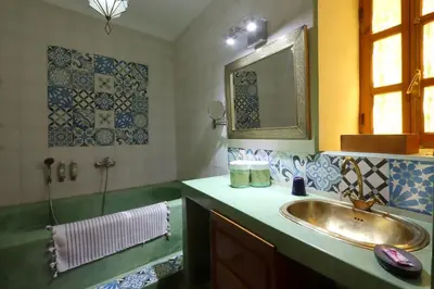 a bathroom with a sink and a mirror and a tub at Riad Al Kamar, private, 2 min from Jema El Fna Square in Marrakech