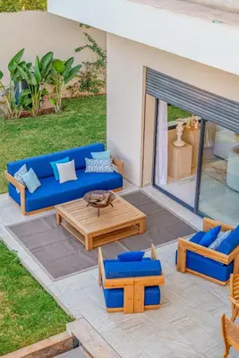 a patio with a blue couch and chairs and a table at Villa Elysée - Piscine et jardin Privée Sans vis-à-vis Wifi HD in Sraghna