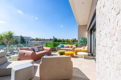 a patio with couches and tables and chairs at Villa Elysée - Piscine et jardin Privée Sans vis-à-vis Wifi HD in Sraghna