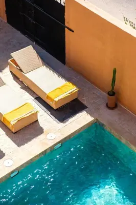 two beds and a swimming pool next to a building at Villa d Exception 5 suites et piscine privee in Marrakech