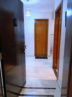 an empty hallway with a wooden door and a hallwayngth at Apartement Gueliz Marrakech in Marrakech