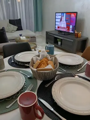 a table with plates and a bowl of bread on it at Apartement Gueliz Marrakech in Marrakech