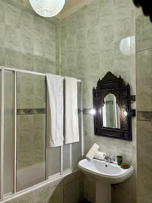 a bathroom with a sink and a shower and a mirror at Family residence with a pool in Marrakech