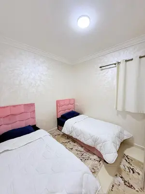 a bedroom with two beds and a window at Appartement Calme Parfait & Centre-ville in Marrakech