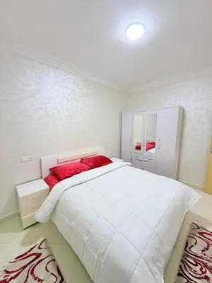a bedroom with a large white bed with red pillows at Appartement Calme Parfait & Centre-ville in Marrakech