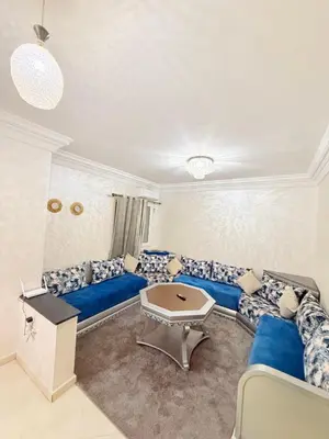 a living room with a blue couch and a table at Appartement Calme Parfait & Centre-ville in Marrakech