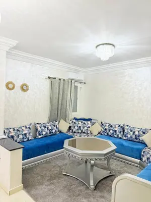 a living room with a blue couch and a table at Appartement Calme Parfait & Centre-ville in Marrakech