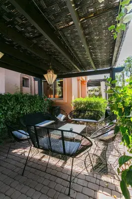 a patio with chairs and tables on a patio at Amelkis Golf Marrakech, Villa 6ch, piscine chauffée in Marrakech