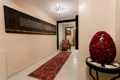 a hallway with a red chair and a rug at Amelkis Golf Marrakech, Villa 6ch, piscine chauffée in Marrakech