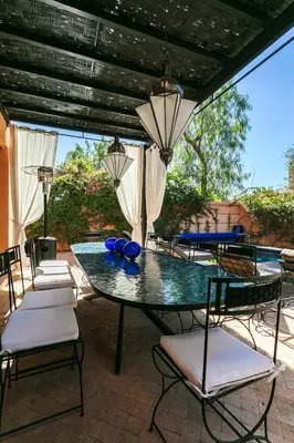 a patio with a table and chairs on a patio at Amelkis Golf Marrakech, Villa 6ch, piscine chauffée in Marrakech