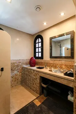 a bathroom with a sink and a mirror at Amelkis Golf Marrakech, Villa 6ch, piscine chauffée in Marrakech