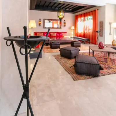 a living room with a table in the middle of a room at Amelkis Golf Marrakech, Villa 6ch, piscine chauffée in Marrakech