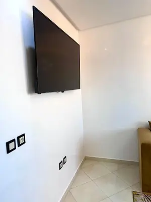 a flat screen tv on a white wall at RENTSUITE SPACIOUS and COMFY 2 BEDROOM in Marrakech