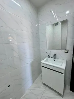 a white bathroom with a sink and a mirror at RENTSUITE SPACIOUS and COMFY 2 BEDROOM in Marrakech
