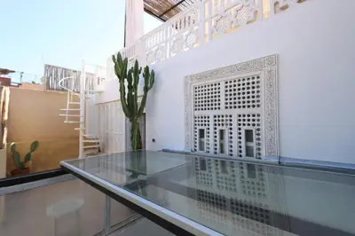 a glass table in a room with a vase at Dar Bensuh 2ch privé in Marrakech
