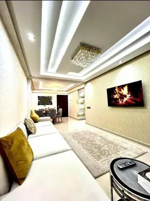 a living room with two beds and a tv on the wall at Apartment au cœur de Marrakesh in Marrakech