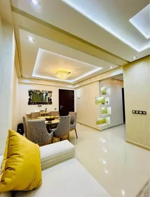 a living room with a couch and a dining room at Apartment au cœur de Marrakesh in Marrakech