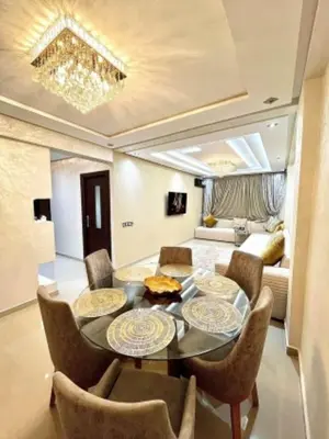 a living room with a table and chairs and a couch at Apartment au cœur de Marrakesh in Marrakech