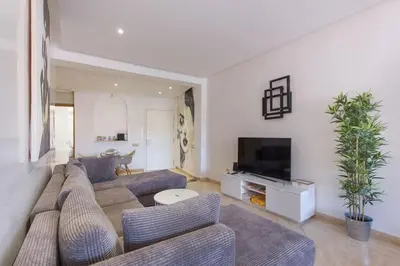 a living room with a couch and a tv at Urban Chic 2 bedrooms in Utimate City Center in Marrakech