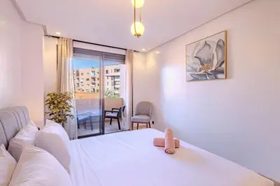 a bedroom with a white bed and a balcony at New 1BR appt in gueliz in Marrakech