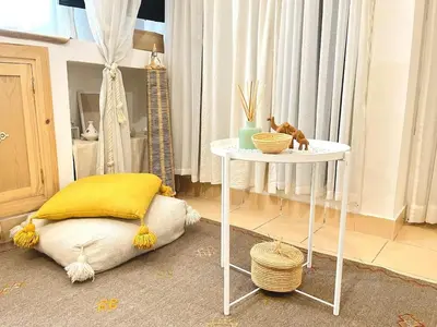 a room with a table with a yellow pillow and a table with a tablength at Comfort bubble ideally located in Guéliz in Marrakech