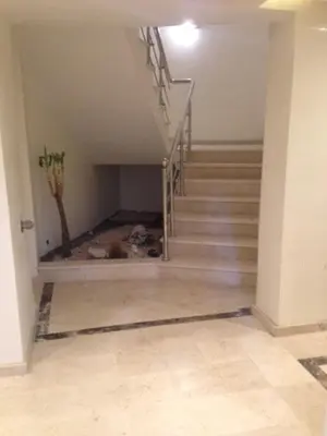 a hallway with stairs and a cat laying on the floor at Appartement Meublé Au Centre de Gueliz in Marrakech