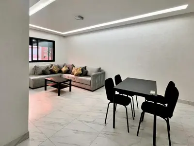 a living room with a table and a couch at Appartement De Luxe Avec Piscine a Marrakech in Marrakech
