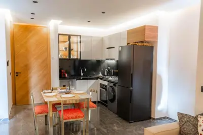 a kitchen with a table and a black refrigerator at Nuit d'Amazay in Marrakech