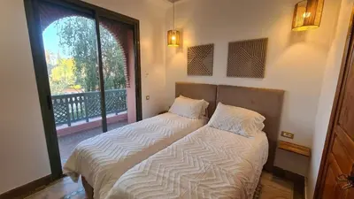 a bedroom with two beds and a large window at Marrakech Palmeraie 2 appt 2ch, résidence avec piscine in Marrakech
