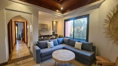 a living room with a blue couch and a table at Marrakech Palmeraie 2 appt 2ch, résidence avec piscine in Marrakech