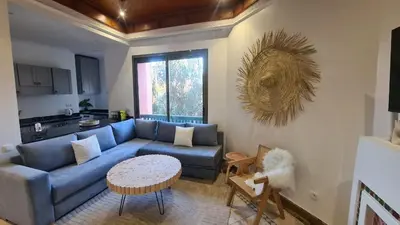 a living room with a blue couch and a table at Marrakech Palmeraie 2 appt 2ch, résidence avec piscine in Marrakech