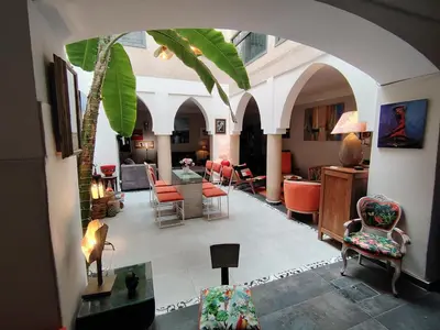 a living room with an archway with chairs and a table at Riad Dom in Marrakech