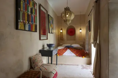 a bedroom with a bed and a desk and a chair at Dar Lysis private with pool and breakfasts in Marrakech