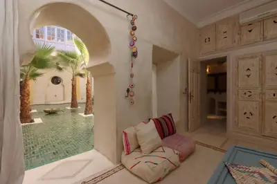 a living room with a couch in a room with a pool at Dar Lysis private with pool and breakfasts in Marrakech