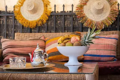 a table with a bowl of fruit on a couch at Dar Lysis private with pool and breakfasts in Marrakech