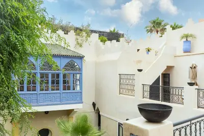 a house with a blue window and a balcony at Dar Lysis private with pool and breakfasts in Marrakech