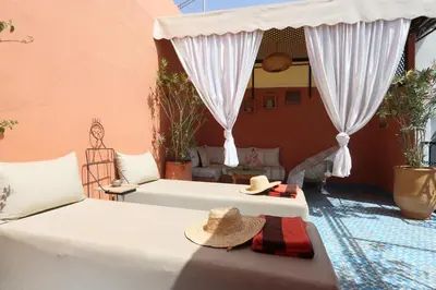 a living room with a bed and a pool at riad la girafe blanche de marrakech in Marrakech