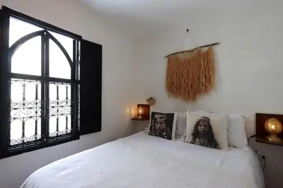 a bedroom with a white bed with a window at riad la girafe blanche de marrakech in Marrakech